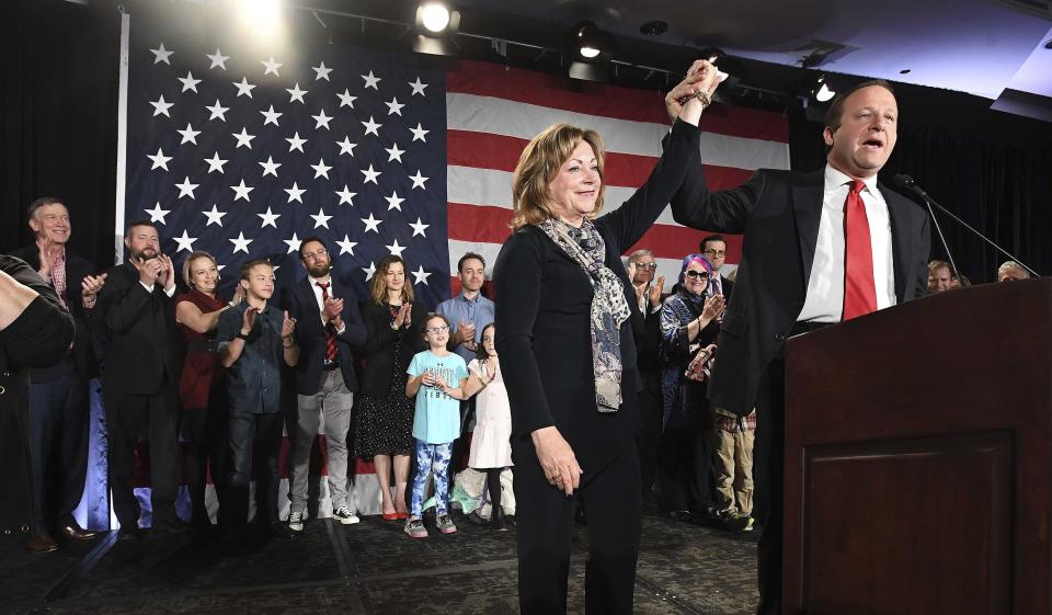 Colorado Governor-elect Jared Polis, right, lifts the hand of Lt. Governor-elect Dianne Primavera during his acceptance speech at the watch party for Colorado Democrats at the Westin Hotel in downtown Denver, Tuesday, Nov. 6, 2018. (Jerilee Bennett/The Gazette via AP)