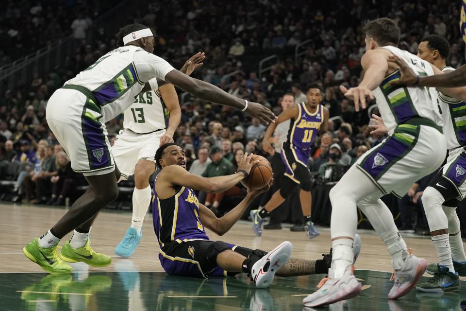 Los Angeles Lakers' Talen Horton-Tucker looks to pass from the floor during the first half of an NBA basketball game against the Milwaukee Bucks Wednesday, Nov. 17, 2021, in Milwaukee. (AP Photo/Morry Gash)
