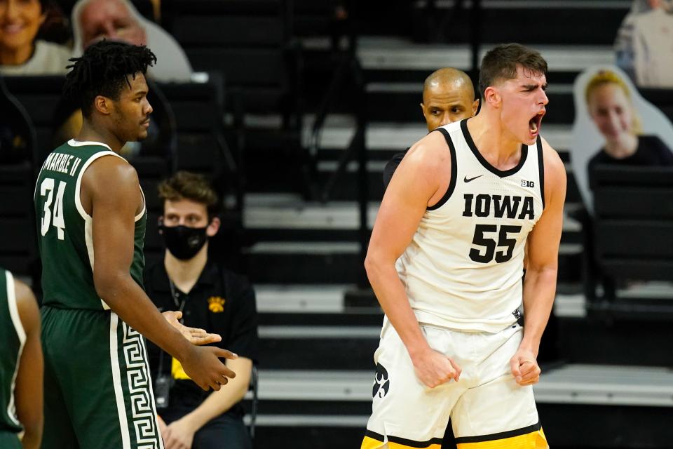 Iowa center Luka Garza celebrate in front of Michigan State forward Julius Marble II, left, after making a basket during the first half on Tuesday, Feb. 2, 2021, in Iowa City, Iowa.