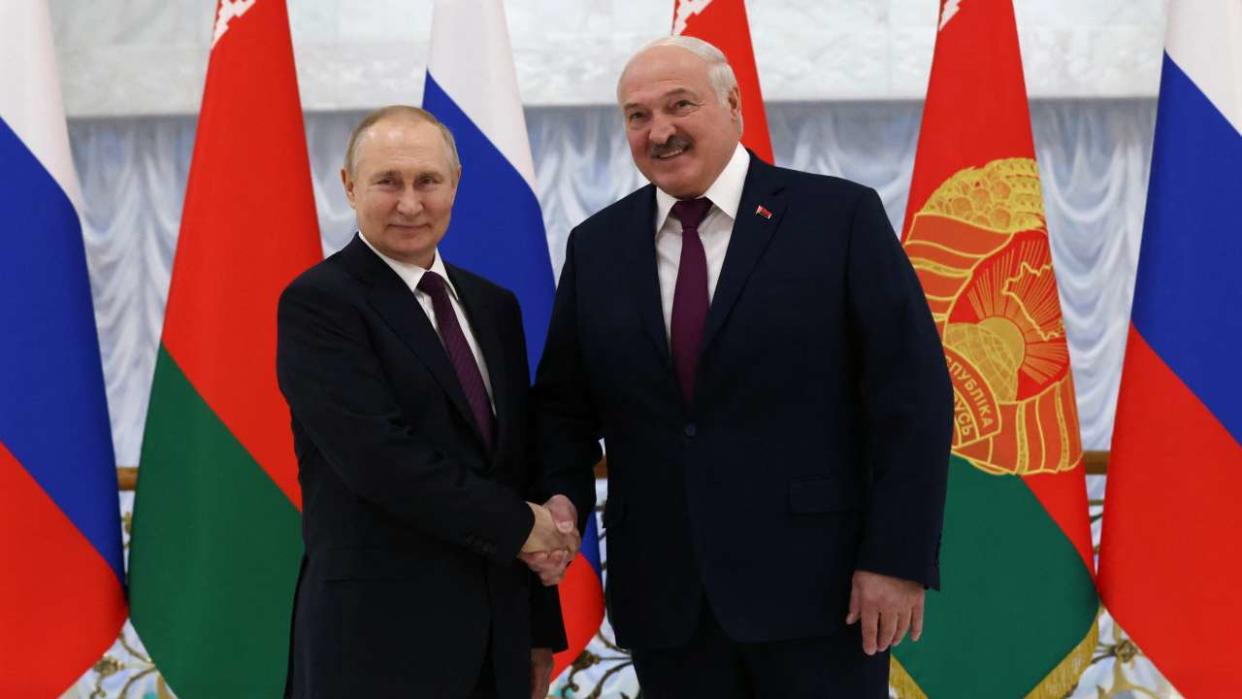 Russian President Vladimir Putin (L) and Belarusian President Alexander Lukashenko shake hands before their meeting at the Palace of Independence in Minsk on December 19, 2022. (Photo by Konstantin ZAVRAZHIN / SPUTNIK / AFP) / *Editor's note : this image is distributed by Russian state owned agency Sputnik*