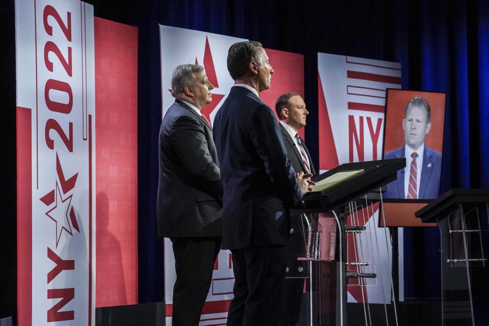 Businessman Harry Wilson, far left, former Westchester County Executive Rob Astorino, second from left, Suffolk County Congressman Lee Zeldin, second from right, and Andrew Giuliani, far right, son of former New York City Mayor Rudy Giuliani, face off during New York's Republican gubernatorial debate at the studios of CBS2 TV, Monday, June 13, 2022, in New York. Giuliani participated via virtual broadcast after he was blocked from the studios for not meeting vaccine requirements. (AP Photo/Bebeto Matthews)