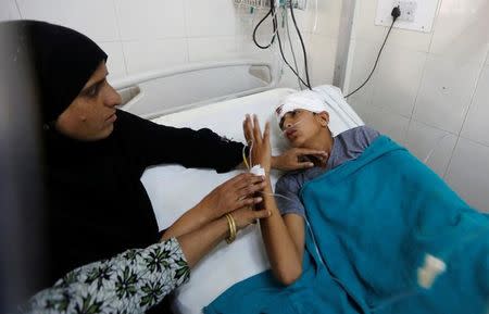 A boy, who got injured during clashes between police and protesters, talks to her mother at a hospital in Srinagar, July 10, 2016. REUTERS/Danish Ismail