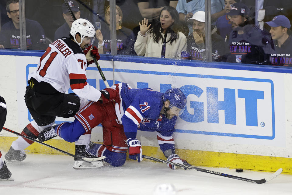 New York Rangers center Barclay Goodrow (21) battles for the puck with New Jersey Devils defenseman Jonas Siegenthaler (71) in the second period of Game 3 of the team's NHL hockey Stanley Cup first-round playoff series Saturday, April 22, 2023, in New York. (AP Photo/Adam Hunger)