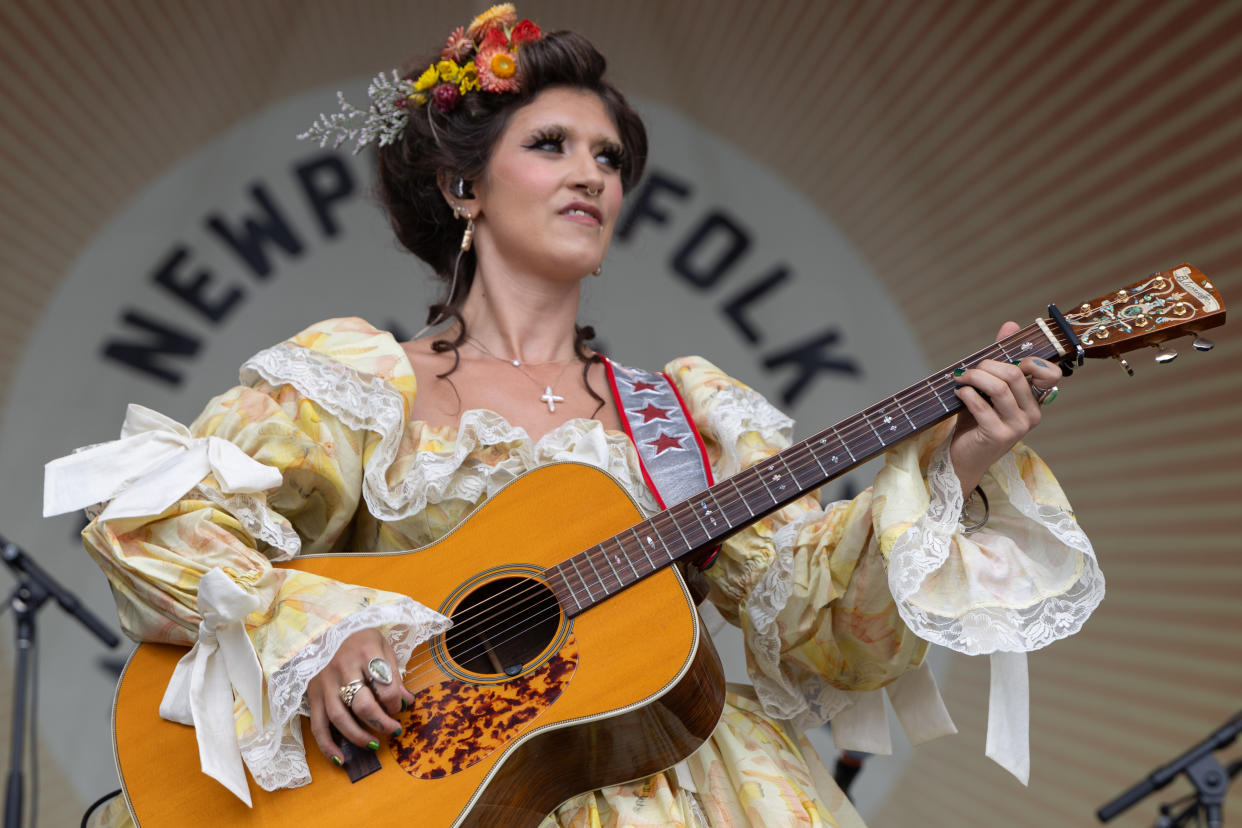 Sierra Ferrell holds a guitar onstage.