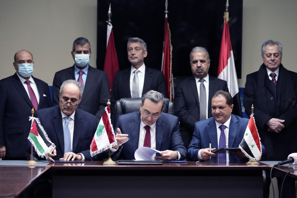 Front row from left to right, wldAmjad Rawashdeh, the Managing General Director of the Jordanian National Electric Power Company, Kamal Hayek, the Director of Electricity of Lebanon, and Fawaz al-Zaher, General Manager of Syrian Electricity Transmission and Distribution, sign deals to bring electricity from Jordan through Syria to Lebanon, at the Ministry of Energy and Water in Beirut, Lebanon, Wednesday, Jan. 26, 2022. Lebanon's electricity company offers only a couple of hours of power a day, and residents have heavily relied on costly and polluting private generators since the end of the civil war in 1990. (AP Photo/Bilal Hussein)