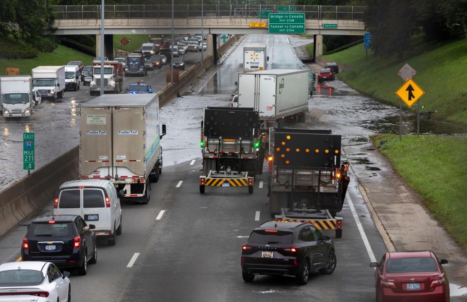 Dozens of vehicles drive through a flooded section of Interstate 94 in Detroit on Friday, Aug. 25, 2023.