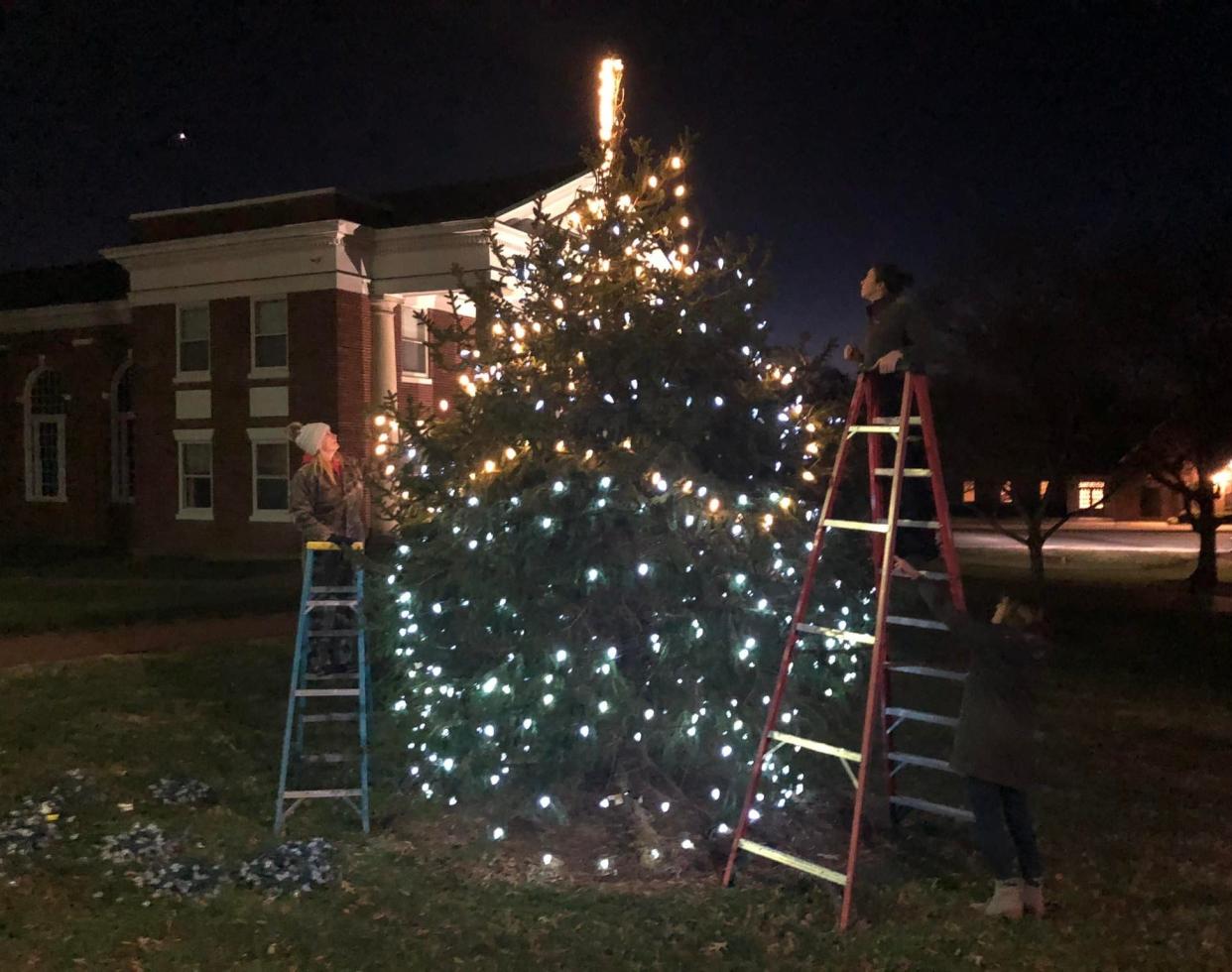Volunteers decorate the Christmas tree on the Courthouse Square in Amelia in December 2021.