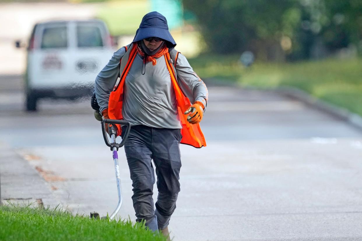 Salvador Alfredo wears protective clothing as he works outside Tuesday, June 27, 2023, in Houston. Meteorologists say scorching temperatures brought on by a heat dome have taxed the Texas power grid and threaten to bring record highs to the state.