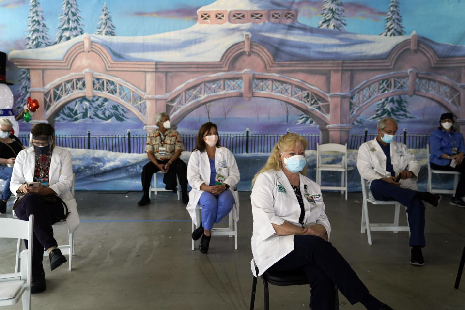 FILE - In this Jan. 7, 2021, file photo, medical workers wait in the holding area after getting the Pfizer-BioNTech COVID-19 vaccine at St. Joseph Hospital in Orange, Calif. The rapid expansion of vaccinations to senior citizens across the U.S. has led to bottlenecks, system crashes and hard feelings in many states because of overwhelming demand for the shots. (AP Photo/Jae C. Hong, File)