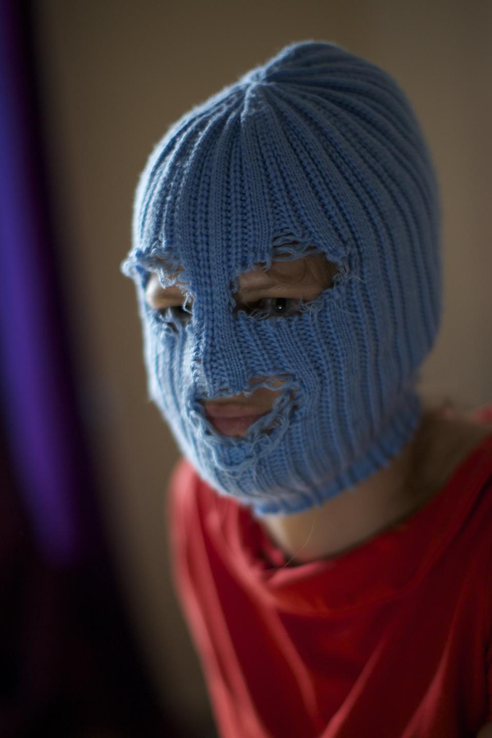 A member of Russian punk band Pussy Riot, who gave only her stage name of Grelka, wears a blue balaclava as speaks to the media in Moscow, Tuesday, July 16, 2013. Russian provocateurs Pussy Riot are back in action, releasing their first music video since three members went to prison last year for a prank denouncing Vladimir Putin. The video shows band members in trademark bright-colored balaclavas and short skirts, cavorting and shrieking atop an oil rig. Backed by hectic guitar and a drum fusillade, they pour oil on a large photo of state oil giant Rosneft’s chairman and liken Putin to an Iranian ayatollah. Pussy Riot member Grelka said after the video’s Tuesday release that “the main message is that Putin has spread the country’s wealth among his friends.” (AP Photo/Alexander Zemlianichenko)