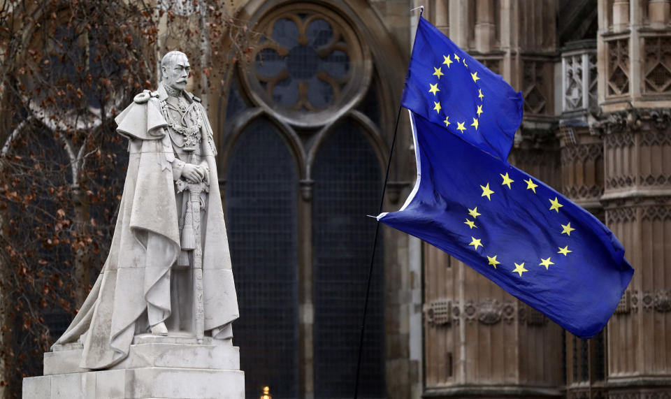 The EU flags wave next to the statue of King George V in Westminster, London, Wednesday, Jan. 16, 2019. British lawmakers overwhelmingly rejected Prime Minister Theresa May's divorce deal with the European Union on Tuesday, plunging the Brexit process into chaos and triggering a no-confidence vote that could topple her government. (AP Photo/Frank Augstein)