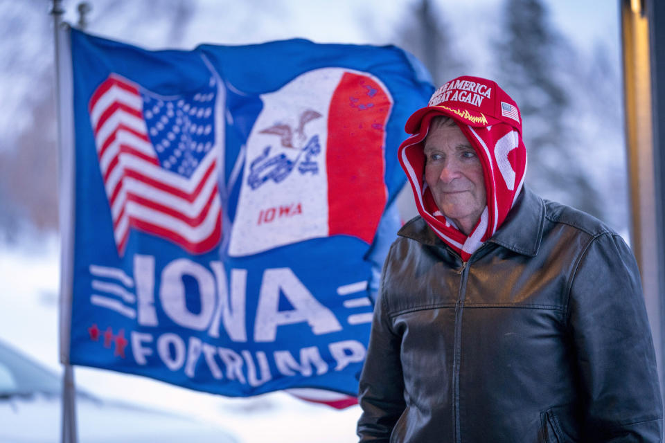 FILE - A man stands next to a flag that reads "Iowa for Trump" outside the the Machine Shed in Urbandale, Iowa, Jan. 11, 2024. Voters in Iowa will participate in caucuses Monday, Jan. 15, that will launch the GOP presidential nomination process. (AP Photo/Andrew Harnik, File)