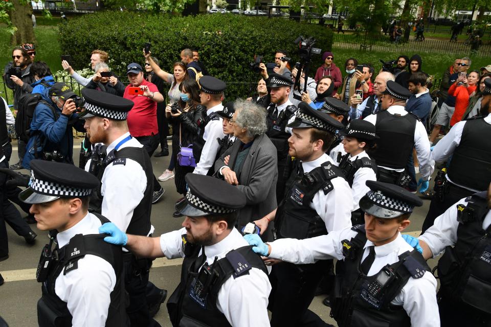 Piers Corbyn (C), brother of former Labour Party leader Jeremy Corbyn, is led away by police officers at an anti-coronavirus lockdown demonstration in Hyde Park in London on May 16, 2020, following an easing of lockdown rules in England during the novel coronavirus COVID-19 pandemic. - Fliers advertising 'mass gatherings' organised by the UK Freedom Movement to oppose the government lockdown measures and guidelines put in place to halt the spread of coronavirus in parks around the UK calling for attendees to bring a picnic and music have been circulating on social media. People are being asked to "think carefully" before visiting national parks and beaches on the first weekend since coronavirus lockdown measures were partially eased in England. (Photo by JUSTIN TALLIS / AFP) (Photo by JUSTIN TALLIS/AFP via Getty Images)