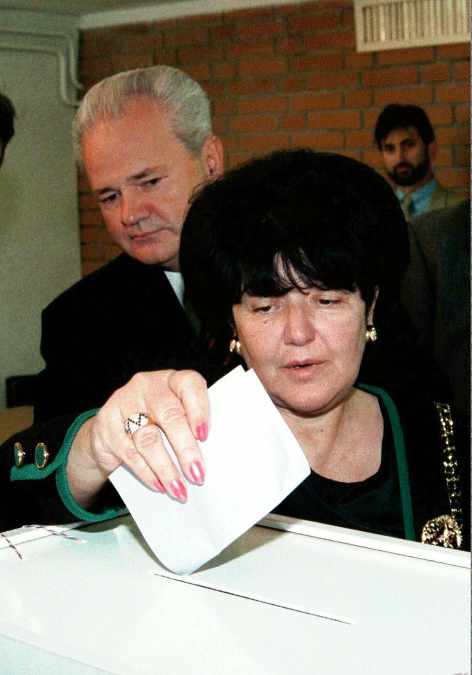 FILE - In this Sunday, Oct. 5, 1997 file photo, Mirjana Markovic, right, the wife of Yugoslav president Slobodan Milosevic, votes, left, in Sunday's presidental Serbian elections, in Belgrade. Serbia’s state television said that Mirjana Markovic, the widow of former strongman Slobodan Milosevic who was considered a power behind the scene behind his autocratic rule, has died in Russia on Saturday. She was 76, it was reported on Sunday, April 14, 2019. (AP Photo /Darko Vojinovic, File)