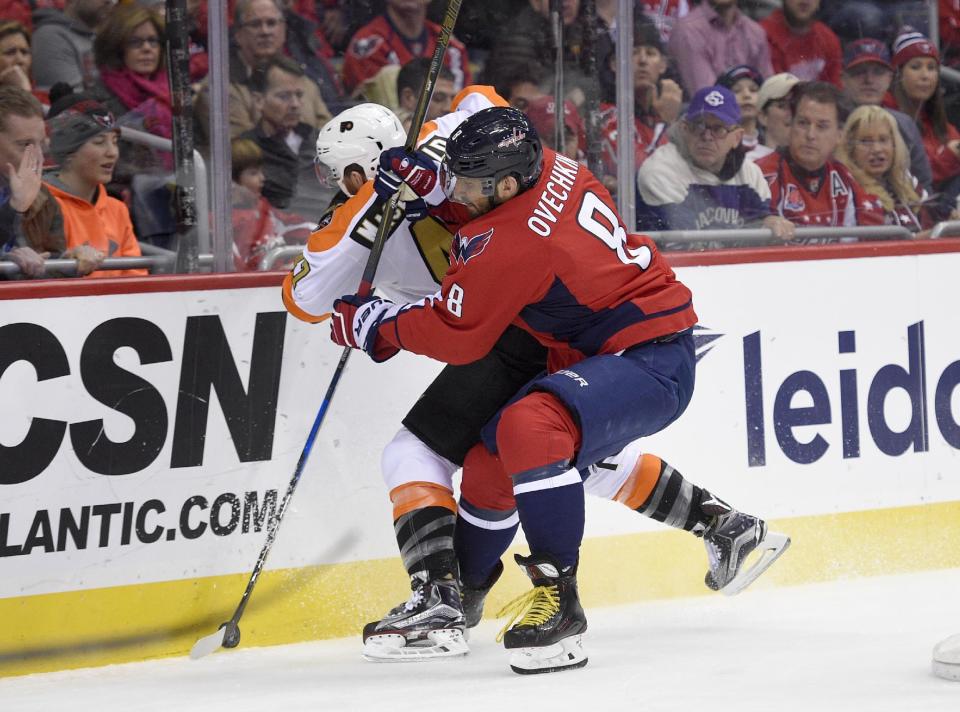 Washington Capitals left wing Alex Ovechkin (8), of Russia, battles for the puck against Philadelphia Flyers defenseman Andrew MacDonald (47) during the first period of an NHL hockey game, Sunday, Jan. 15, 2017, in Washington. (AP Photo/Nick Wass)