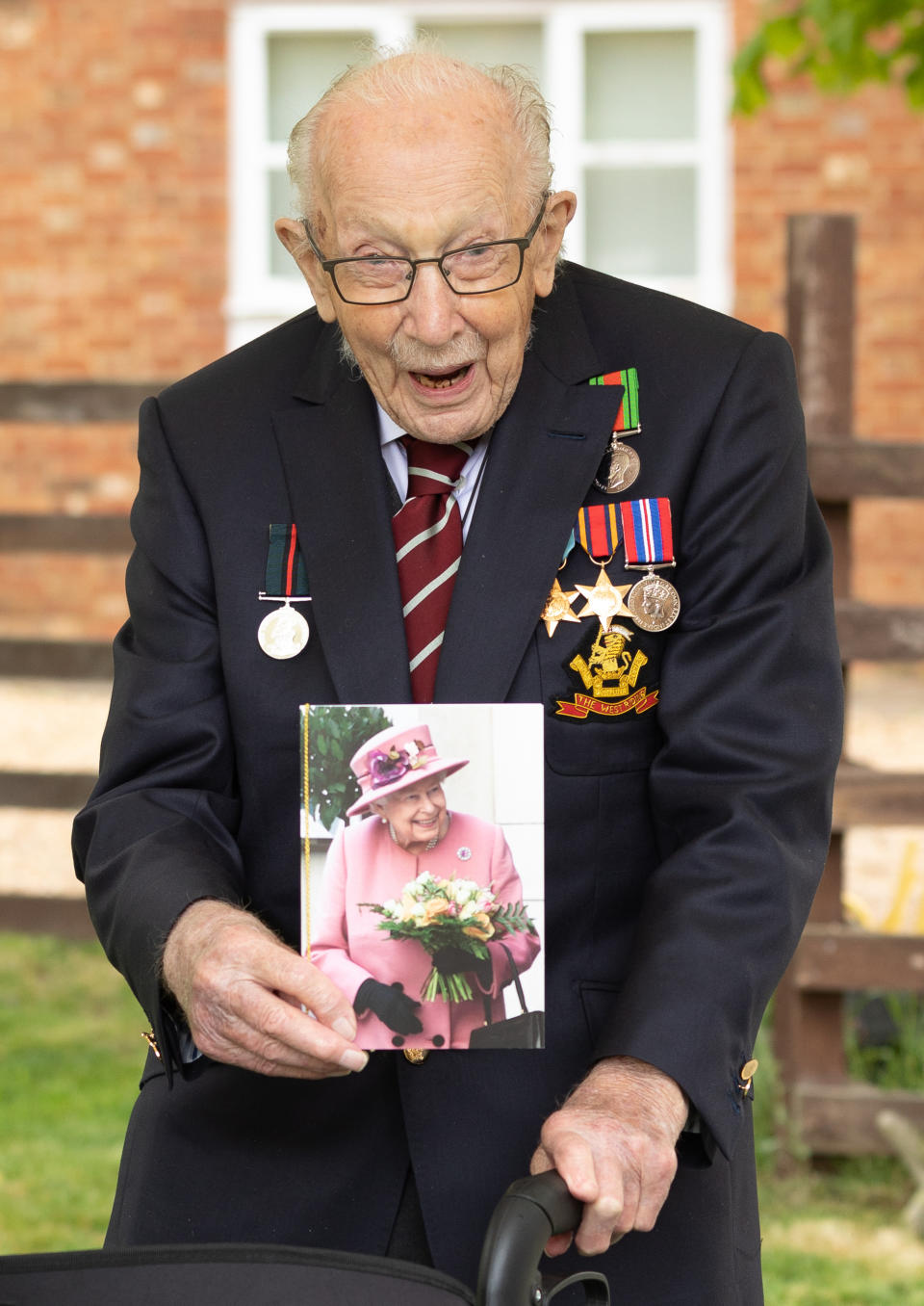 Handout photo of Second World War veteran Captain Tom Moore holding a birthday card from Queen Elizabeth II as he celebrates his 100th birthday.