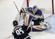 St. Louis Blues goaltender Jordan Binnington, back, stops a shot off the stick of Colorado Avalanche left wing Andre Burakovsky in the first period of an NHL hockey game Saturday, Jan. 18, 2020, in Denver. (AP Photo/David Zalubowski)