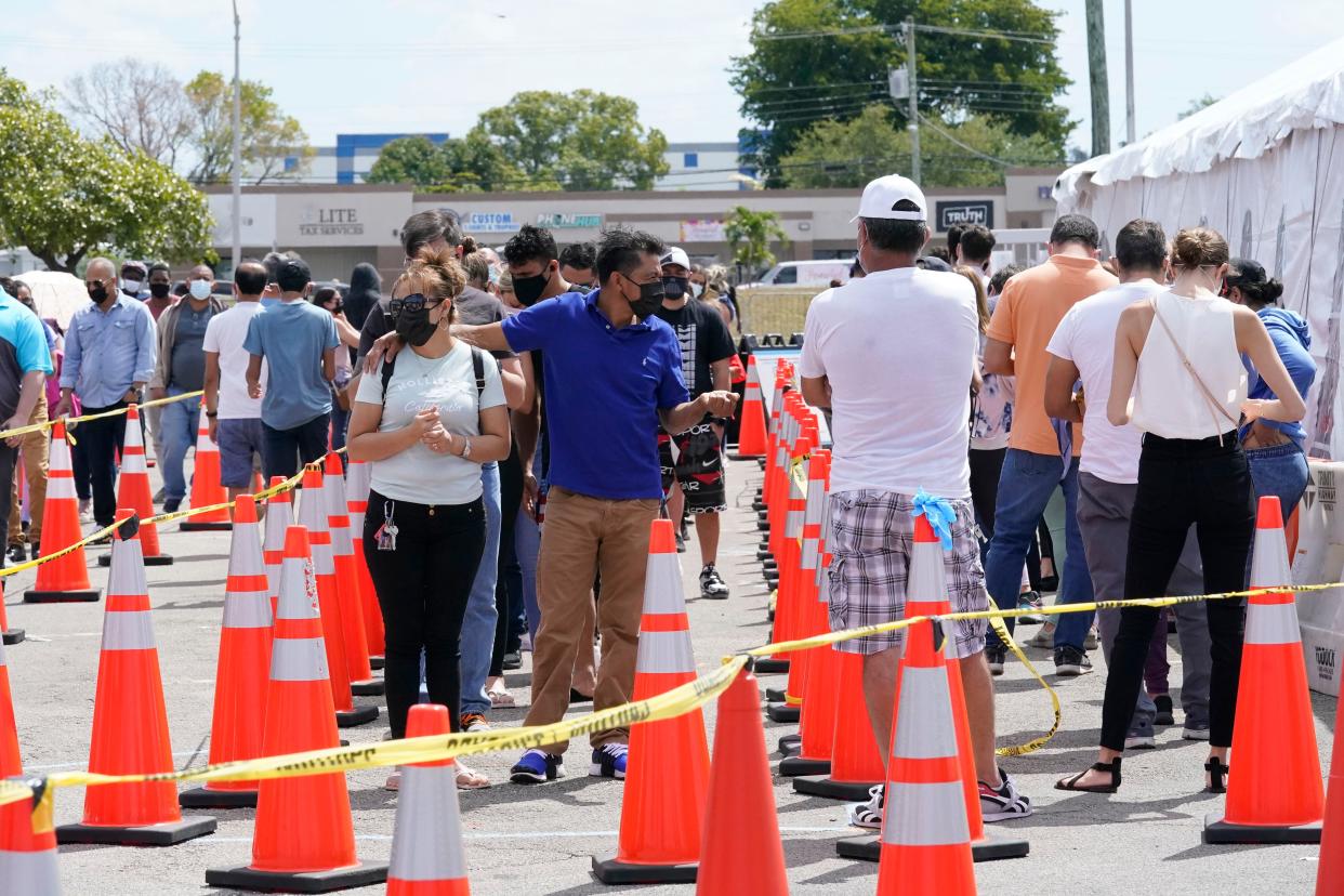 People wait in line to receive a COVID-19 vaccine at a FEMA vaccination center at Miami Dade College on Monday, April 5, 2021, in Miami.