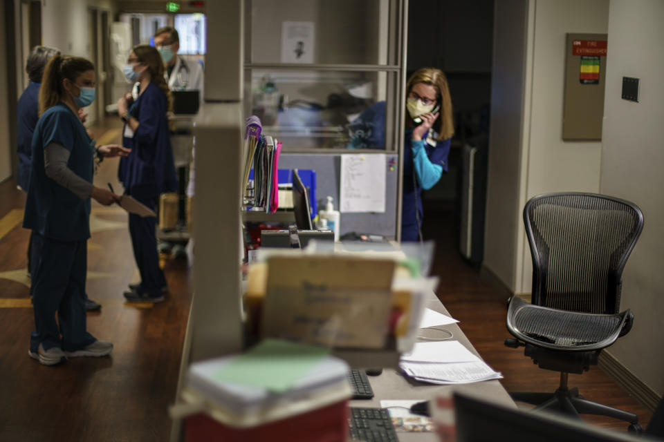 A chair sits at the nurses station where Jennifer McClung worked as a longtime dialysis nurse at Helen Keller Hospital in Sheffield, Ala., Monday, March 7, 2022. In November of 2020, McClung, 54, tested positive for COVID-19. "Mama, I feel like I'm never coming home again," she texted her mother, Stella Olive, from a hospital bed. Her lungs severely damaged by the virus, she died just hours before the nation's vaccination campaign began on December 14. Today, a decal with a halo and angel's wings marks the place McClung once occupied at a third-floor nurses' station. "It still just seems like. She could just walk through the door," McClung's mother says. "I haven't accepted that she's she's gone. I mean, a body is here one day and talking and laughing and loving and and then, poof, they're just gone." (AP Photo/David Goldman)