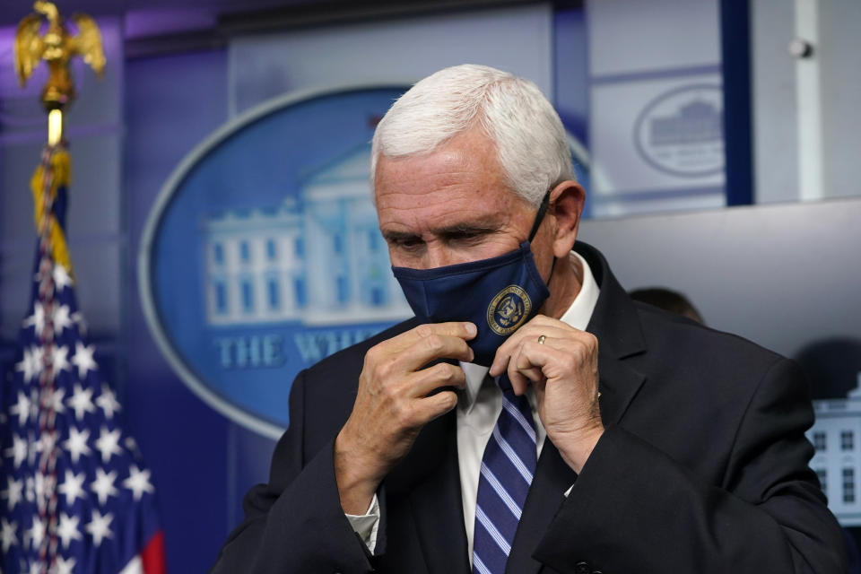 Vice President Mike Pence puts on his mask after speaking during a briefing with the coronavirus task force at the White House in Washington, Thursday, Nov. 19, 2020. (AP Photo/Susan Walsh)