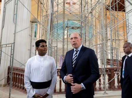 Australian Minister of Home Affairs Peter Dutton and a priest talk at the St.Sebastian's church where two Australian citizens died in the Easter Sunday bombing, during his visit in Negombo