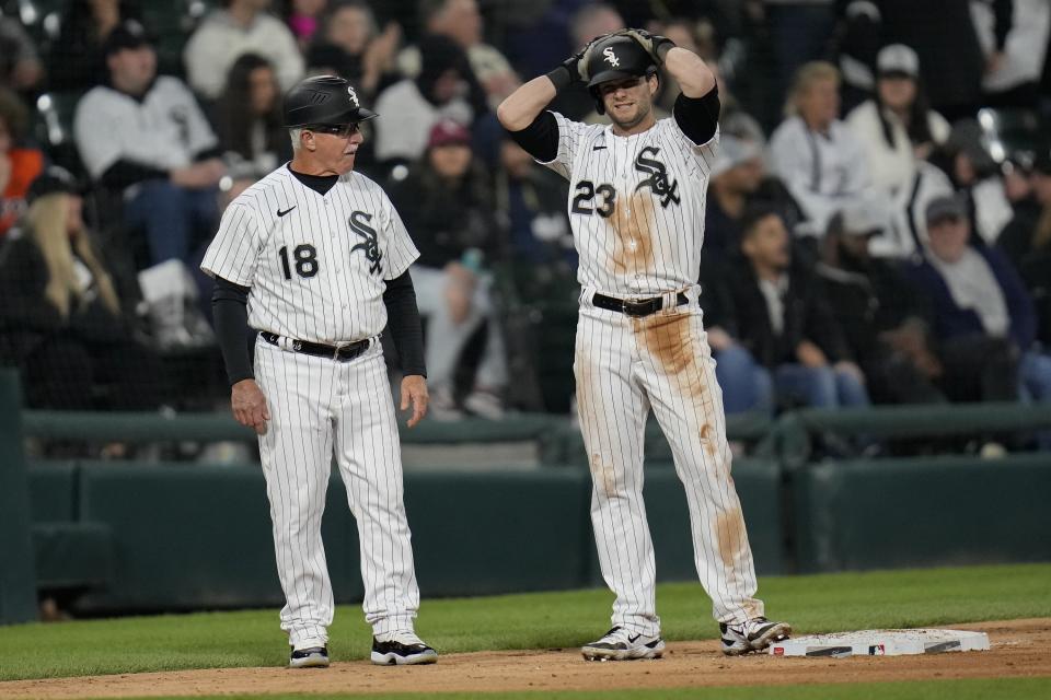 Chicago White Sox's Andrew Benintendi, right, stands next to third base coach Eddie Rodriguez, left, after stealing second and then making it to third after Houston Astros second baseman Mauricio Dubon missed a throw from catcher Cesar Salazar during the seventh inning of a baseball game Saturday, May 13, 2023, in Chicago. (AP Photo/Erin Hooley)