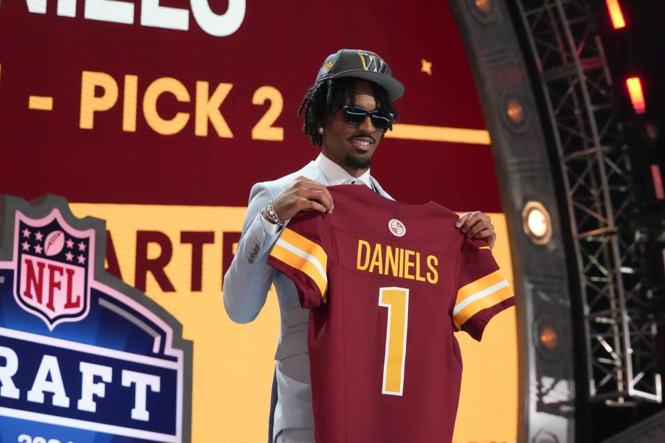 LSU Tigers quarterback Jayden Daniels poses after being selected by the Washington Commanders as the No. 2 pick in the first round of the 2024 NFL Draft at Campus Martius Park and Hart Plaza.