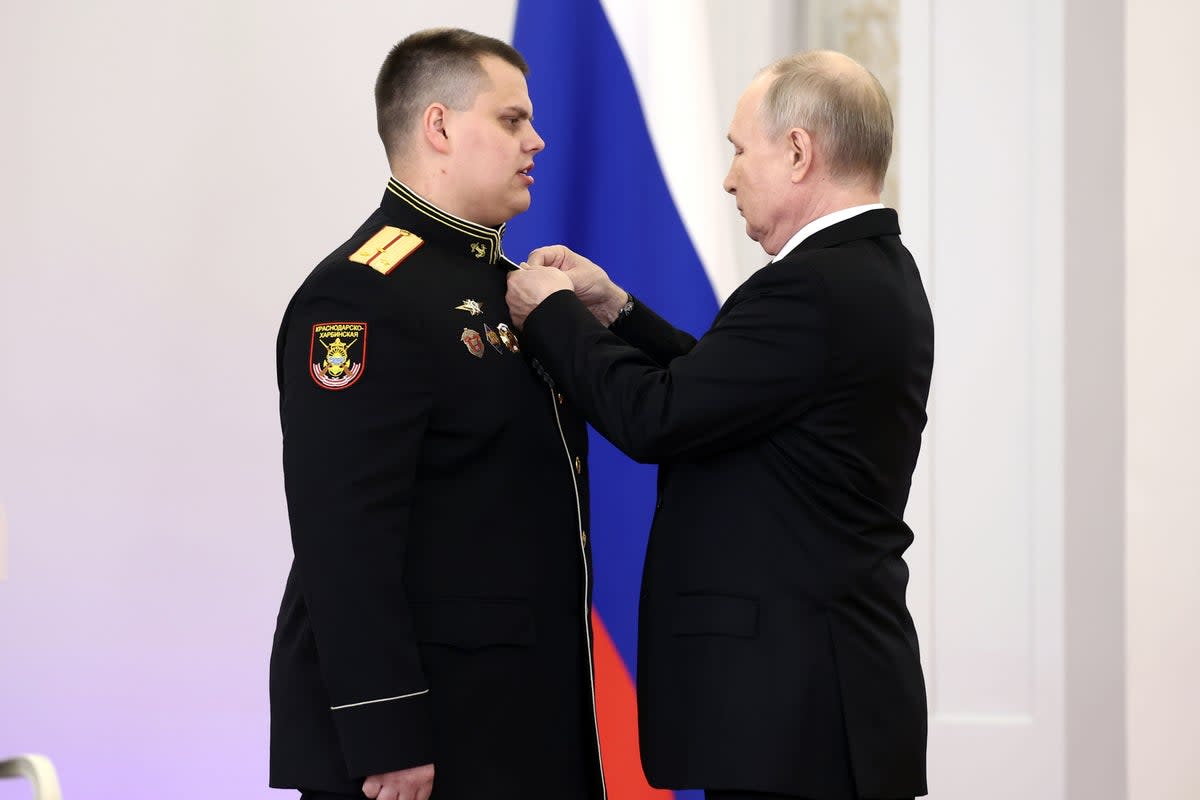Vladimir Putin (R) announced his intention to run for a fifth presidential term during a stage-managed awards ceremony with soldiers who had fought in Ukraine (EPA)