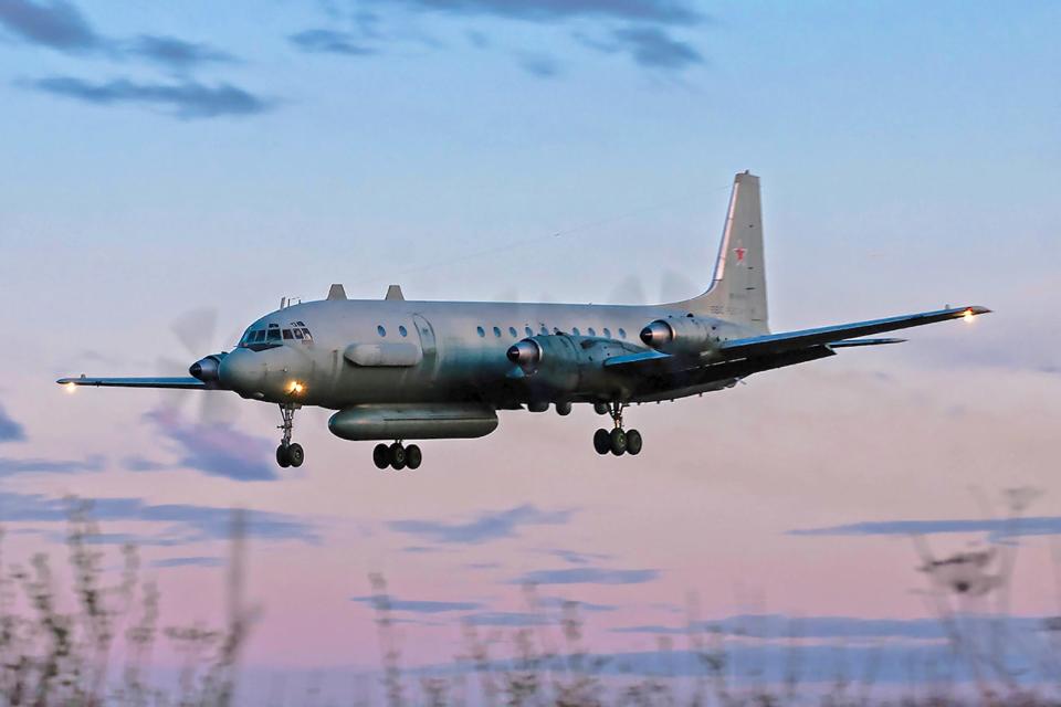 A Russia IL-20M about to land on a runway with it's landing gear down.