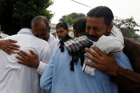 Men mourn the death of ra elative, who was killed during an earthquake, in Jatlan, Mirpur