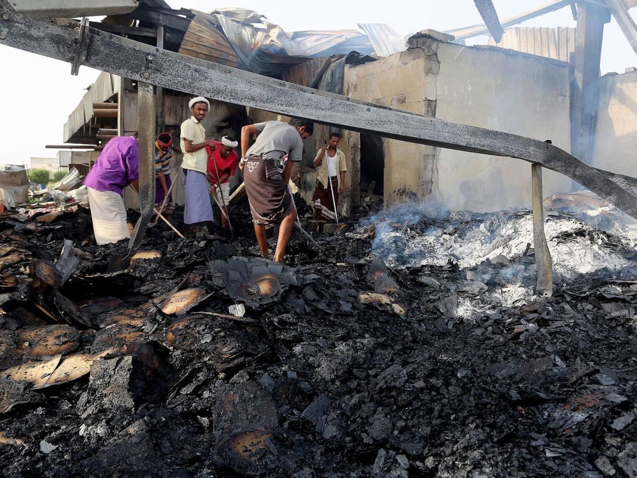 Yemeni men inspect the damages at a factory allegedly targeted by Saudi-led coalition's airstrikes in the Red Sea town of Hodeidah on 27 July 2018: AFP/Getty