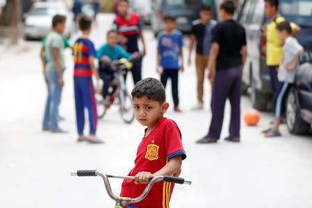 Palestinian refugee children play in the street in Al-Baqaa Palestinian refugee camp, near Amman