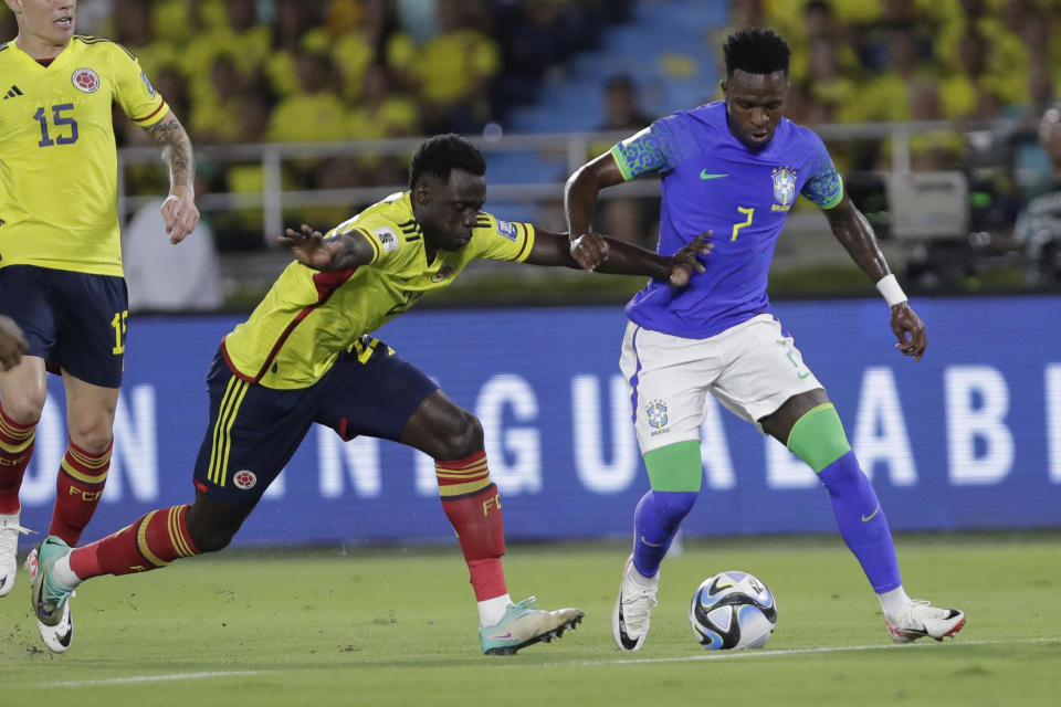 ARCHIVO - El brasieño Vinicius Junior y el colombiano Davinson Sánchez disputan el balón en el partido por las eliminatorias del Mundial, el jueves 16 de noviemnbre de 2023, en Barranquilla, Colombia. (AP Foto/Iván Valencia, File)