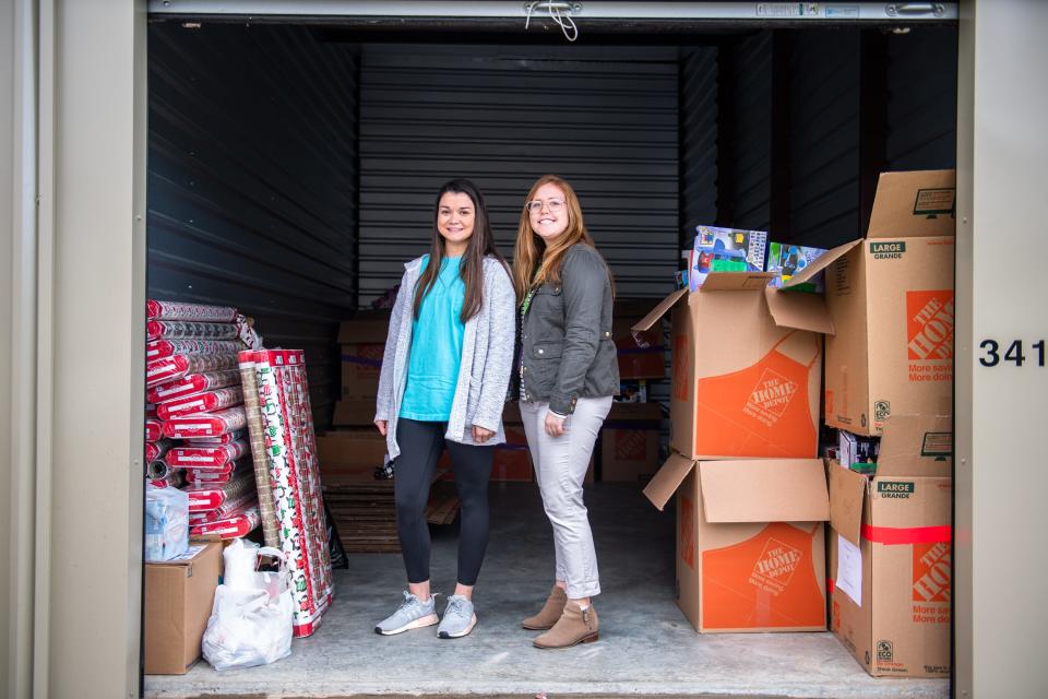 Annamaria Tormey, the Clemson Hope Adopt a Classroom director, and Price Crenshaw, the founder and former executive director, pose for a portrait in a storage unit Tuesday, November 12, 2019, with boxes of toys to be gifted to title 1 elementary school students.