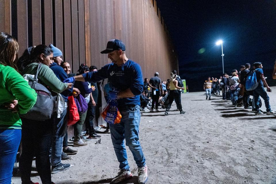 Fernando Quiroz, Yuma resident and director of the AZ-CA Humanitarian Coalition, hands water to migrants and asylum seekers detained by U.S. Border Patrol agents after crossing the U.S.-Mexico border in Yuma County, near the Cocopah Indian Tribe's reservation, on July 28, 2022.