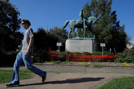 A pedestrian walks past a statue of Civil War Confederate General Robert E. Lee, ahead the one-year anniversary of the fatal white-nationalist rally, in Charlottesville, Virginia, U.S., August 1, 2018. REUTERS/Brian Snyder