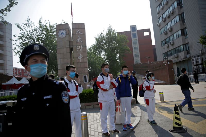 FILE PHOTO: Students wearing face masks leave a school in Beijing
