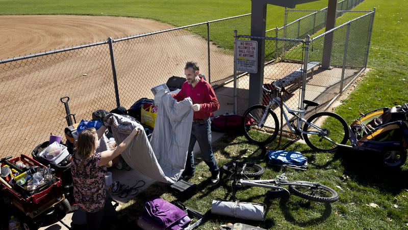 Julie Gommon and Doug Koogle clean cup their camp at Herman Franks Park in Salt Lake City on Friday, Oct. 27, 2023. Both Gommon and Koogle said they would live in a sanctioned camp if possible. They need a place to safely store their belongings while at work.