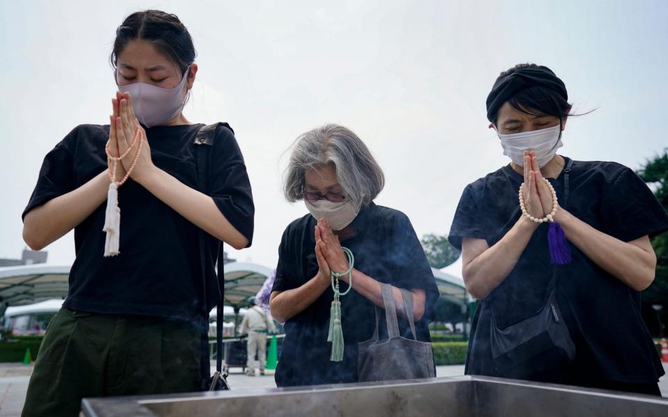 Women pray in front of a cenotaph for the victims of the bombing at Peace Memorial Park in Hiroshima - DAI KUROKAWA/EPA-EFE/Shutterstock /Shutterstock