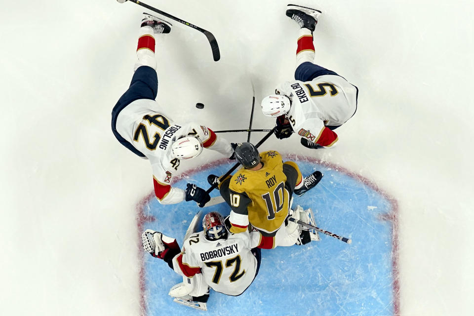 Vegas Golden Knights center Nicolas Roy (10) battles Florida Panthers defenseman Gustav Forsling (42), defenseman Aaron Ekblad (5) and goaltender Sergei Bobrovsky (72) for the puck during the second period of Game 1 of the NHL hockey Stanley Cup Finals, Saturday, June 3, 2023, in Las Vegas. (AP Photo/Abbie Parr)