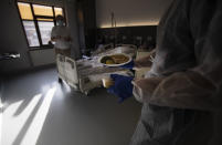 A Belgian Army medic brings lunch to a patient with COVID-19 at the St. Michiel Hospital in Brussels, Tuesday, Nov. 24, 2020. The Belgian military has been called into several hospitals and care homes to alleviate the stress on healthcare personnel. (AP Photo/Virginia Mayo)