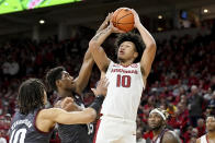Arkansas forward Jaylin Williams, front right, shoots over Texas A&M defenders Henry Coleman III (15) and Ethan Henderson, left, during the first half of an NCAA college basketball game Saturday, Jan. 22, 2022, in Fayetteville, Ark. (AP Photo/Michael Woods)
