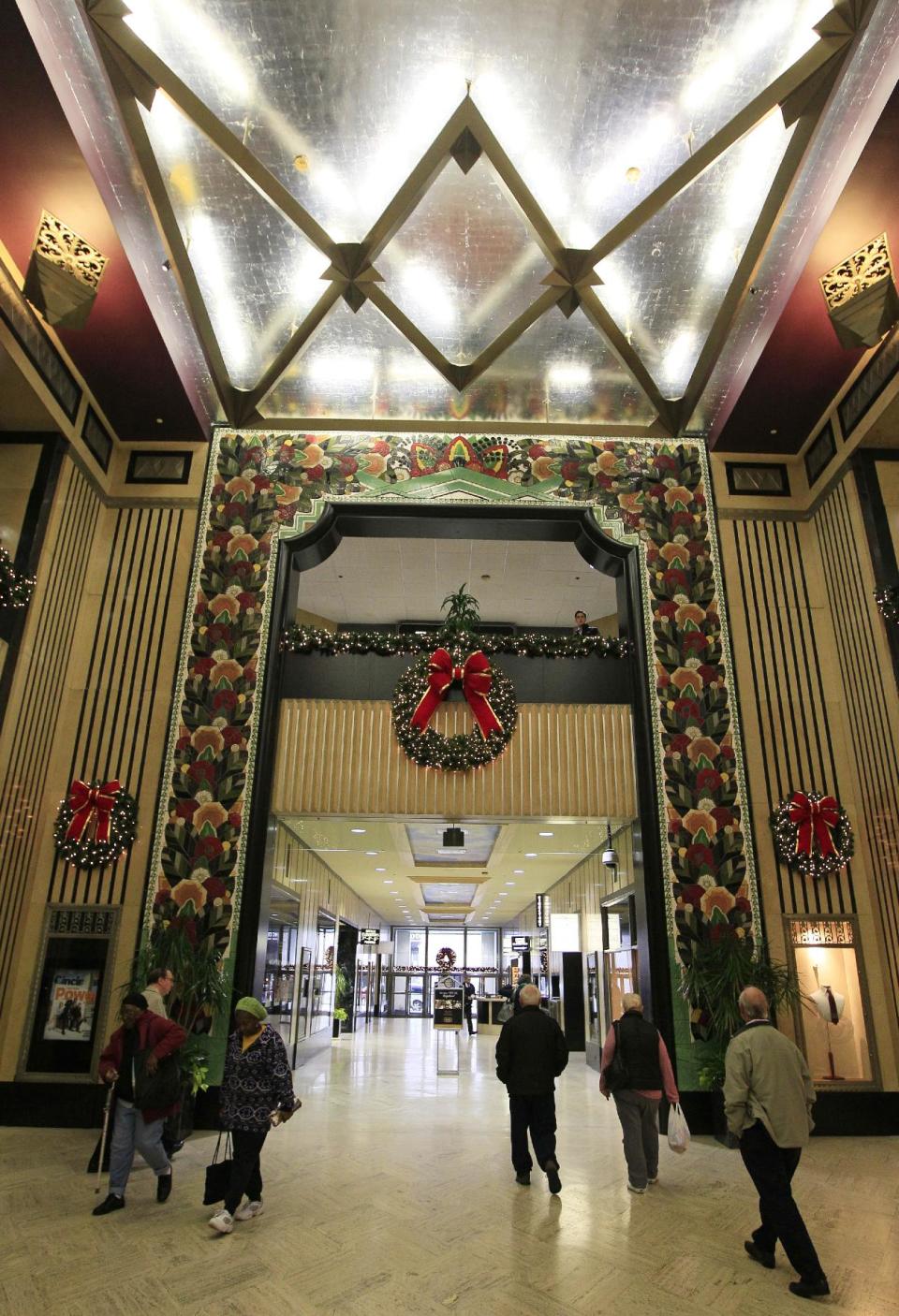 In this Monday, Nov. 19, 2012 photo, people walk through an open area in the Carew Tower that houses the Tower Place Mall in downtown Cincinnati. The city of Cincinnati is trying to take over the long-floundering mall, hoping to find better use for the expanses of vacated retail stores and other abandoned space in the city's ongoing effort to revitalize its downtown. (AP Photo/Al Behrman)