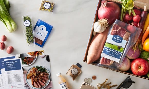 A collection of ingredients from a Blue Apron meal kit including meat and vegetables.