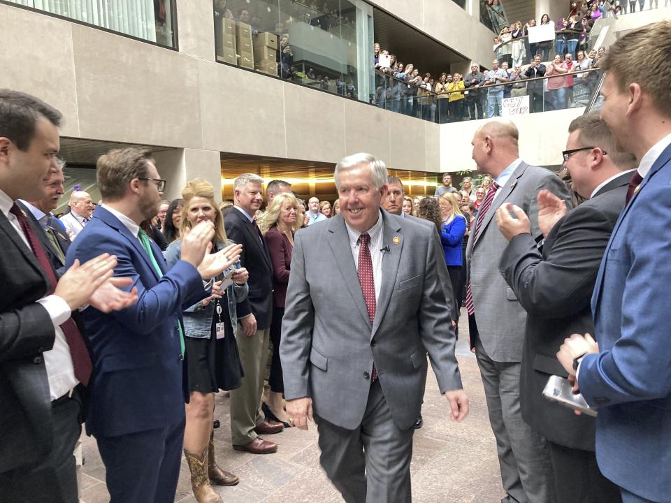 Missouri Gov. Mike Parson is cheered by state employees as he arrives in a state office building to sign legislation funding an 8.7% pay raise on Feb. 27, 2023, in Jefferson City, Mo. State lawmakers approved the pay raise in hopes of retaining and attracting more state employees. (AP Photo/David A. Lieb)