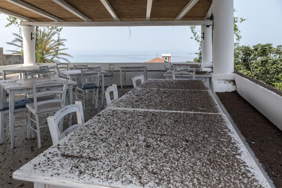 Ashes cover a restaurant's terrace in the port town of Ginostra on July 4, 2019 a day after the Stromboli volcano erupted.