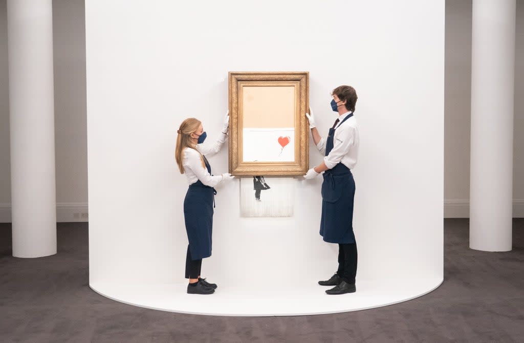 Art handlers at Sotheby’s auction house with Banksy’s Love Is In The Bin, which self-shredded immediately after it was sold at auction (Dominic Lipinski/PA) (PA Wire)