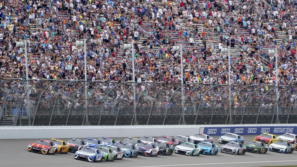 Bubba Wallace (23) leads the field to the start during an NASCAR Cup Series auto race at the Michigan International Speedway in Brooklyn, Mich., Sunday, Aug. 7, 2022. (AP Photo/Paul Sancya)