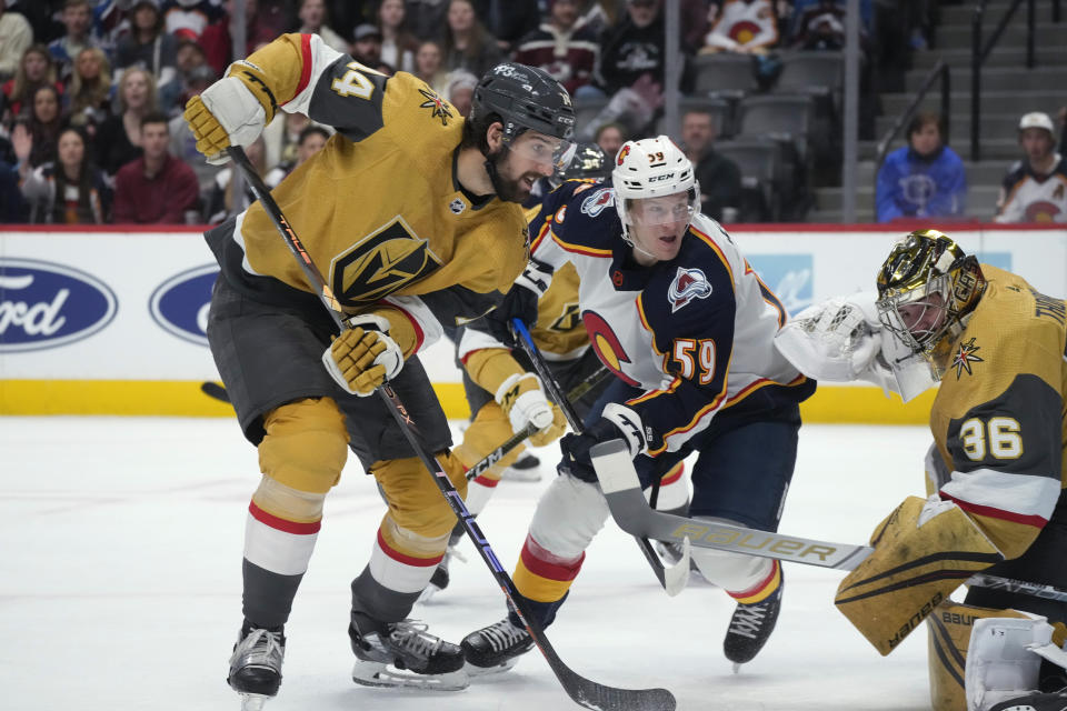 Colorado Avalanche center Ben Meyers, center, shoots the puck wide of the net as Vegas Golden Knights defenseman Nicolas Hague, left, and goaltender Logan Thompson defend in the first period of an NHL hockey game, Monday, Jan. 2, 2023, in Denver. (AP Photo/David Zalubowski)