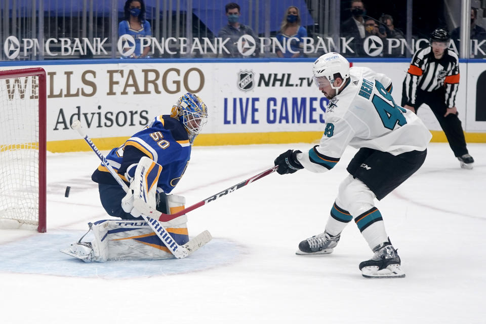 San Jose Sharks' Tomas Hertl, right, scores the game winning goal past St. Louis Blues goaltender Jordan Binnington during a shootout of an NHL hockey game Wednesday, Jan. 20, 2021, in St. Louis. (AP Photo/Jeff Roberson)